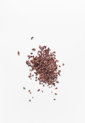 Crushed cocoa beans on white background. Copy space text