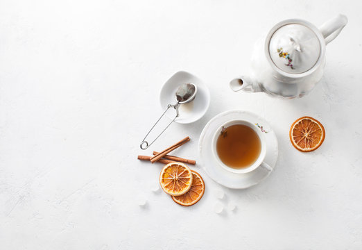 Cup of tea with oranges and cinnamon on a white table. Copy space text