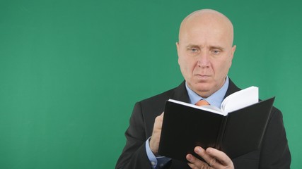 Confident Businessman Read and Write in Agenda With Green Screen Background