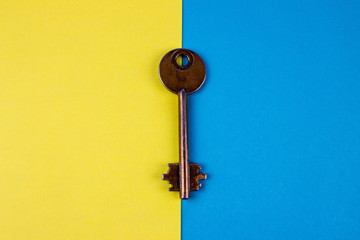 Retro vintage key on blue and yellow background