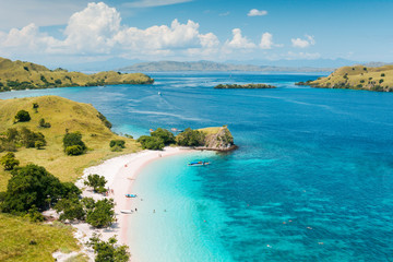 Aerial view of 'Pink Beach' with green color on the hill and turquoise sea from Komodo Island (Komodo National Park), Labuan Bajo, Flores, Indonesia