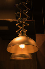 Lamp bulb with light on the ceiling and a selection with black background