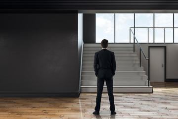 Businessman in modern school corridor