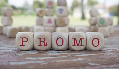 Promo word written on cube shape wooden blocks on wooden table.