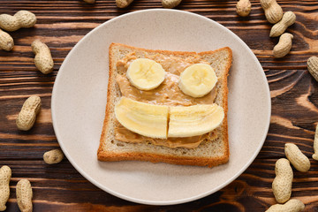 Peanut butter toast with banana slices  on wooden background