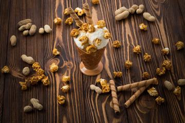 Ice cream with caramel and popcorn on a  black background. Space for text or design.