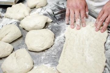 Male hands working with dough in process of pizza and pastry preparation