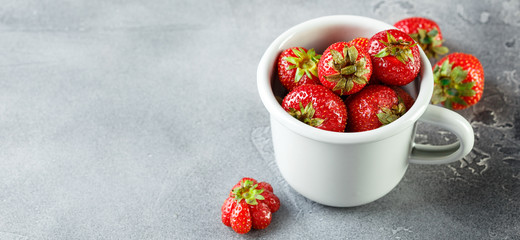 Fresh garden strawberry in enameled mug
