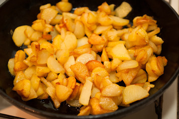 Fried potatoes on black frying pan