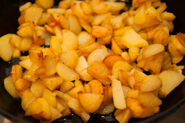 Fried potatoes on black frying pan