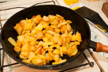 Fried potatoes on black frying pan