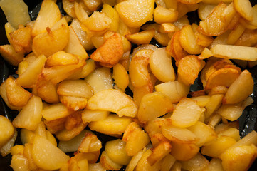 Fried potatoes on black frying pan