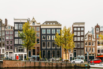 Fototapeta na wymiar Architecture Of Dutch Houses Facade and Houseboats On Amsterdam Canal