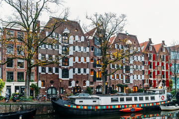 Fototapeta na wymiar Architecture Of Dutch Houses Facade and Houseboats On Amsterdam Canal