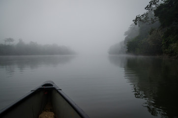 Crossing the Moa river by canoe to Tiwai Island Wildlife Sanctuary during foggy early morning,...
