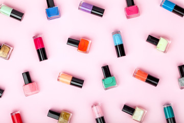 Fototapeta na wymiar bottles of colorful nail polish on pink background. beauty and fashion trendy concept. flat lay, top view