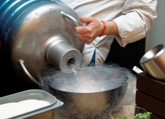 Chef is pouring liquid nitrogen from a large Dewar vessel