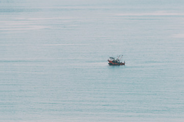 Obraz premium Abstract, minimal, surreal background - small boat sails quietly in sea water. Toned in soft cinematic colors in instagram style.