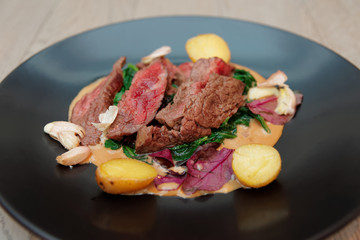 Medium rare fried steak with garlic and potatoes