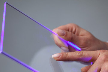 Hands holding futuristic transparent tablet pc