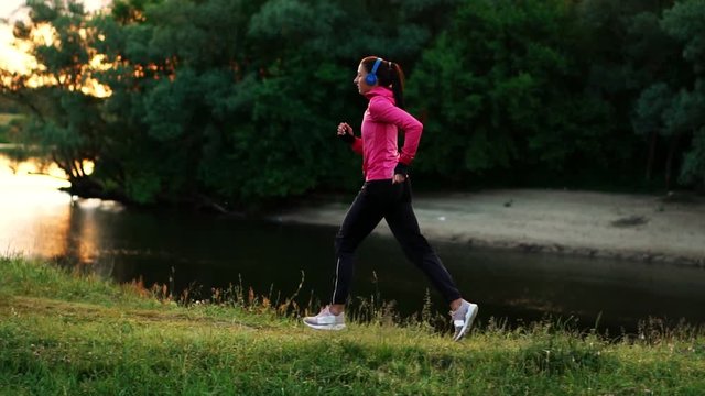 A morning jog in the Park near the pond in the Sunny rays of dawn, the girl is preparing to Mariano and lead a healthy lifestyle
