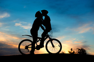 Kiss of young couple at summer sunset. Romantic date on evening nature background. Romantic scenery concept.
