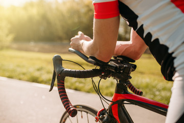 Naklejka premium Male bycyclist in sportswear, cycling on bike path