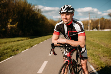 Cyclist in sportswear, cycling on asphalt road