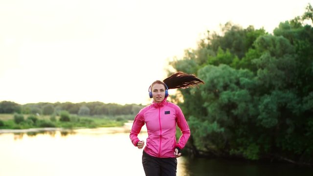 A morning jog in the Park near the pond in the Sunny rays of dawn, the girl is preparing to Mariano and lead a healthy lifestyle