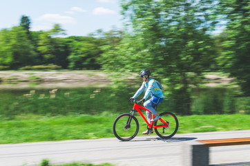Fototapeta premium A cyclist in a helmet rides a bicycle path, motion blur