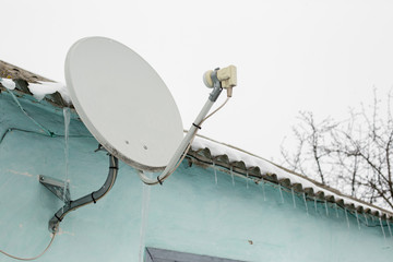 satellite dish at home with blue walls in winter
