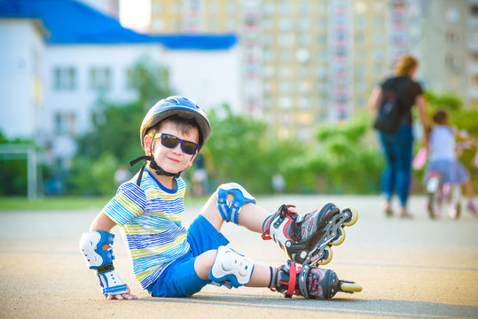 Happy boy in a protective helmet and protective pads for roller skating. Space for text