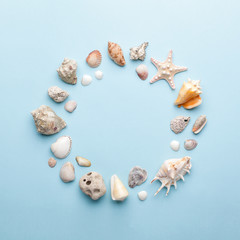 Summer concept with seashells and starfish on pastel blue background. Top view, flat lay.