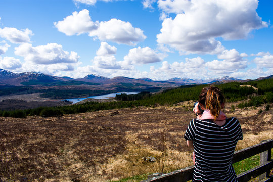 A woman photographer taking a photo of a landscape