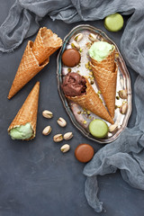 Variety of ice cream  in cones with chocolate and pistachio