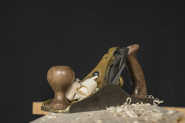 hand plane and shavings on a black background