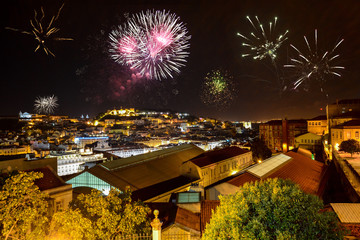 Lisbon at night with fireworks: View from Miradouro Bairro Alto to the castle Castelo de San Jorge and Alfama district, Portugal