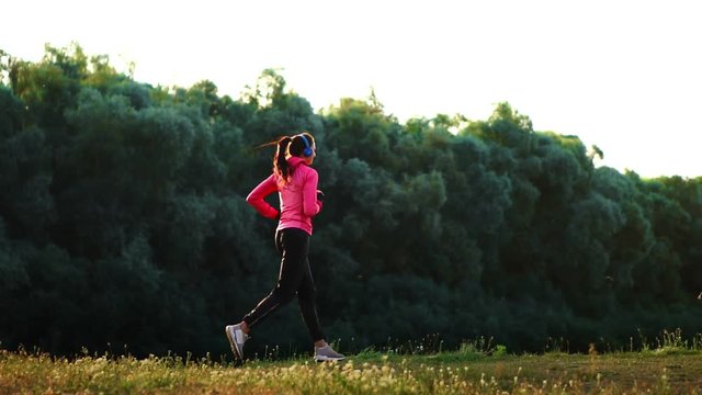 A morning jog in the Park near the pond in the Sunny rays of dawn, the girl is preparing to Mariano and lead a healthy lifestyle