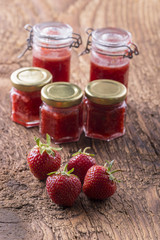 Erdbeermarmelade und Erdbeeren auf Holz