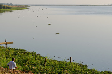 Villager fishing off riverbank in Malawi, Africa