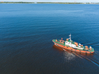 Aerial view of the green red tugboat going along the Finnish Gulf 