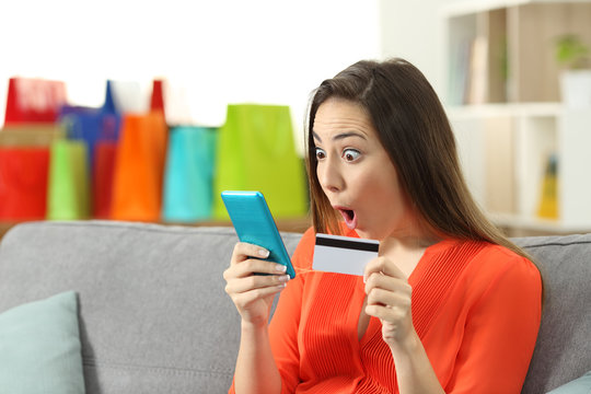 Amazed woman finding online offers holding credit card