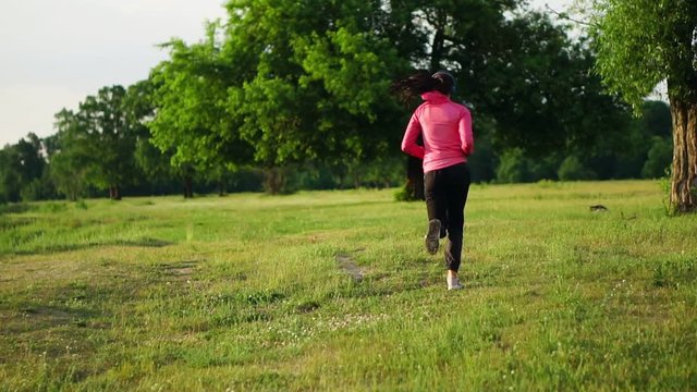 A morning jog in the Park near the pond in the Sunny rays of dawn, the girl is preparing to Mariano and lead a healthy lifestyle