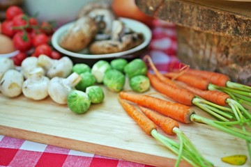Assortment of fresh, raw vegetables for cooking on a wooden cutting board. Selective focus.