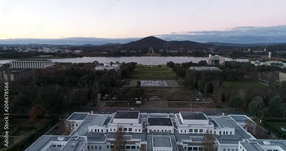 Wall mural Historic old parliament house building on shores of Lake Burley Griffin in Canberra at sunset – aerial view of the roof and distant mt Ainslie hill.
 - Wall murals
