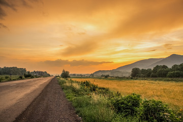 orange sunset evening country side landscape with lonely road concep