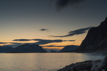 Fototapeta na wymiar View over the Rorvikstranda beach and Gimsoystraumen fjord near Henningsvaer at Lofoten Islands / Norway at midnight