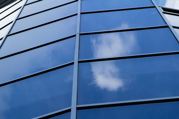 Sky reflected in a modern building blue glass facade