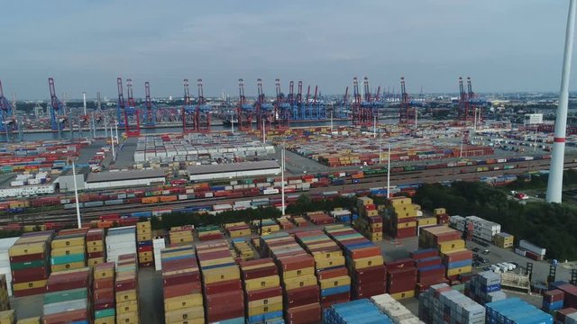 Aerial drone shot of colorful container terminal and cargo train tracks in industrial zone of Port of Hamburg in Germany