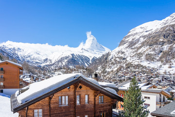 Fototapeta premium Beautiful view of old village in sunny day with Matterhorn peak background in Zermatt, Switzerland.